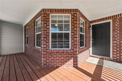 Doorway to property with brick siding and a porch