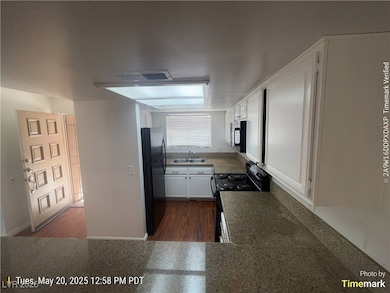Kitchen with a sink, black appliances, white cabin