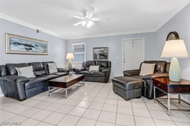 Tiled living room featuring crown molding and ceil