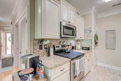 Kitchen featuring visible vents, crown molding, ba