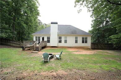 Rear view of house with an outdoor fire pit, a deck, and a chimney