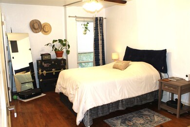 Bedroom with dark wood finished floors and a ceiling fan