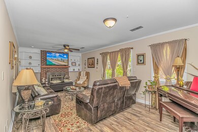 Living room with wood finished floors, visible ven