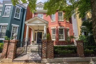 The covered front entrance and raised porch overlook beautiful Park Avenue and a quaint gated courtyard.