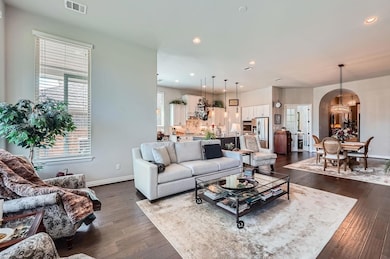 Living area featuring arched walkways, a chandeli