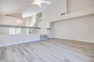 Unfurnished living room featuring high vaulted cei
