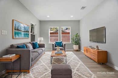 Living area with light wood-style floors and recessed lighting