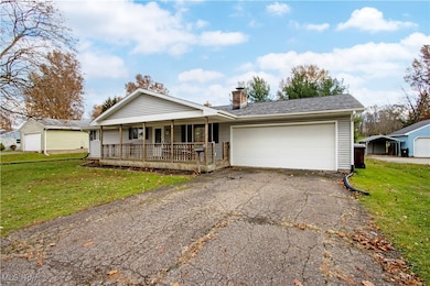 Single story home with a front lawn, a garage, a chimney, and asphalt driveway
