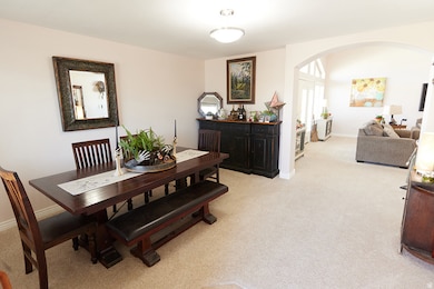 Dining area with light colored carpet and arched walkways