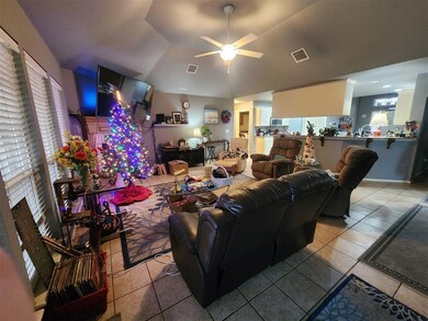 Living room with ceiling fan and light tile flooring