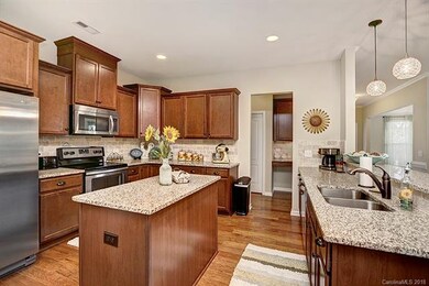 Stainless steel appliances, tiled backsplash and l