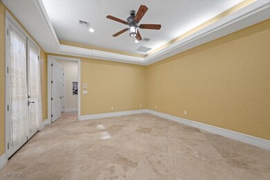 with a fireplace and french doors leading out to the Atrium with a tray ceiling, a ceiling fan, and a textured ceiling