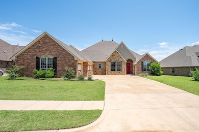 French country inspired facade with brick siding, driveway, a front lawn, and a shingled roof