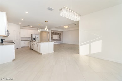 Kitchen with white cabinets, hanging light fixture