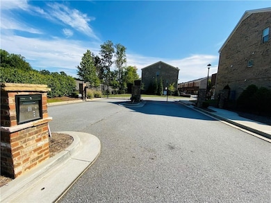 View of asphalt street with a gate, curbs, a gated