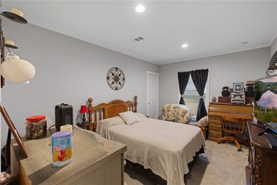 Bedroom with light colored carpet, recessed lighti
