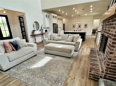 Living area with light wood-style flooring, recessed lighting, and a fireplace