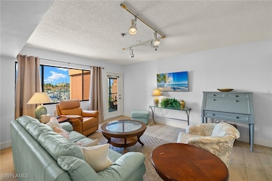 Living area featuring a textured ceiling, light wo
