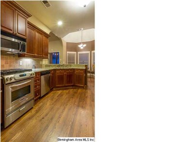 View of kitchen with hardwood floors and the gas s