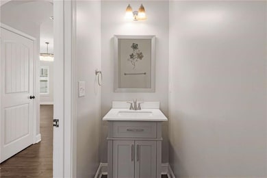 Bathroom featuring vanity, baseboards, and wood finished floors