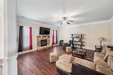 Living area featuring ceiling fan, a fireplace, wo