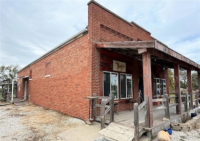 View of property exterior featuring brick siding and a deck
