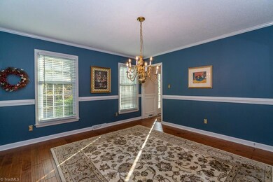 Spacious formal dining room with wide plank flooring, chair rail and moulding.