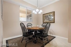 Carpeted dining room with crown molding and an inv