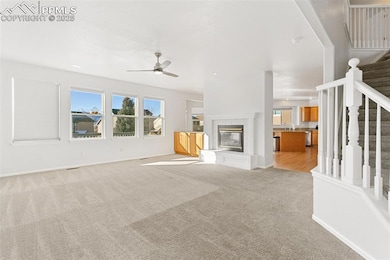 Living room with a tiled fireplace, light carpet, 