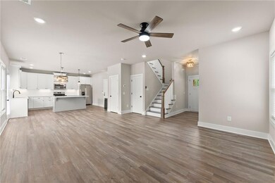 Unfurnished living room featuring a ceiling fan, stairway, light wood-style floors, and recessed lighting