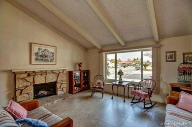 The Formal Living Room Features A Gas And Wood Burning Fireplace, Vaulted Ceilings, Double Pane Front View Window, And Tile Flooring.