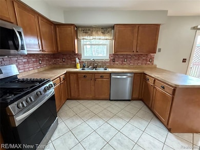 Kitchen featuring brown cabinetry, stainless steel appliances, and light countertops