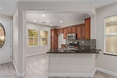 Kitchen featuring decorative backsplash, brown cab