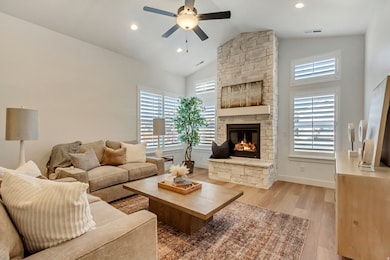 Living room with light wood-type flooring, high vaulted ceiling, a fireplace, recessed lighting, and a ceiling fan