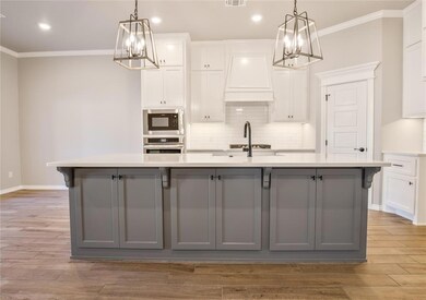 Kitchen featuring premium range hood, pendant ligh