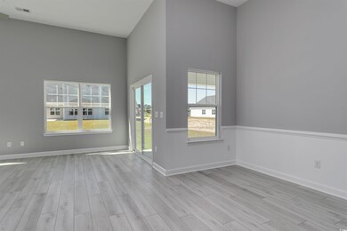 Empty room featuring light wood-type flooring and a high ceiling