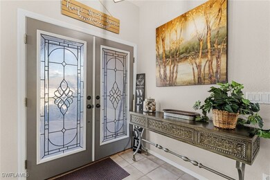 Foyer with french doors and light tile patterned f