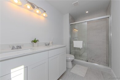 Full bath featuring a stall shower, marble look ti