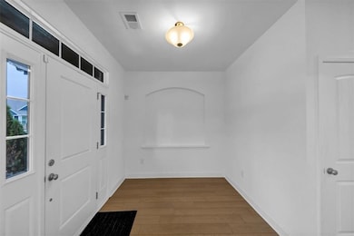 Foyer with wood finished floors and baseboards