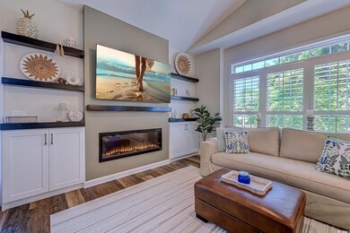 Living room featuring a glass covered fireplace, w