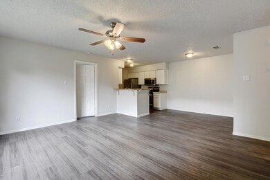 Unfurnished living room with ceiling fan, dark wo