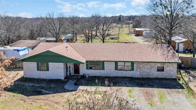 Single story home with brick siding, a storage shed, and roof with shingles