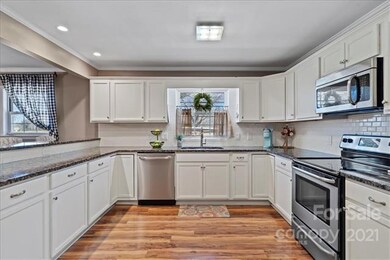 Large kitchen with tall bar top leading into dinin