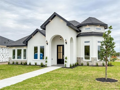 View of front of house featuring stone siding, a front yard, and a shingled roof