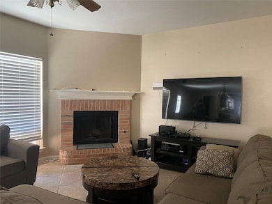 Tiled living room featuring a brick fireplace and a ceiling fan