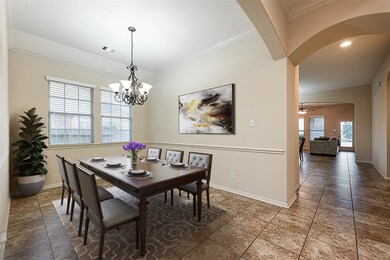 You and your guests will certainly dine in style under the captivating chandelier in this amazing formal dining room! Featuring a gorgeous arched walkway, large windows with privacy blinds, neutral paint, high ceilings, crown molding, and beautiful tile flooring! The perfect space to entertain family and friends!