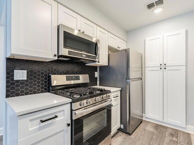 Kitchen featuring white cabinetry, visible vents,