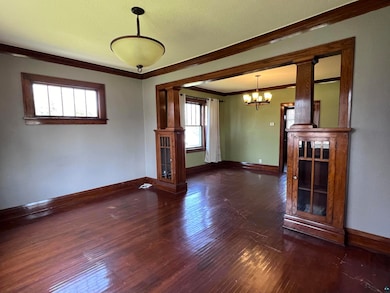Spare room featuring ornamental molding, an inviting chandelier, and hardwood / wood-style flooring