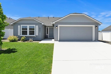 Single story home featuring driveway, an attached garage, and roof with shingles