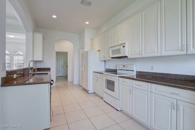 Kitchen with visible vents, a sink, white applianc